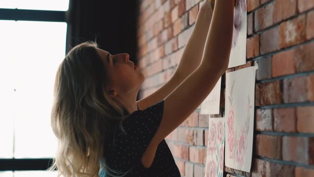 Artwork inspiration. Artist sticking paintings on the wall.