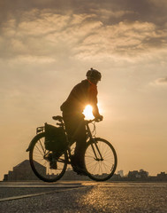 silhouette of man on bike in sunset