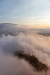Beautiful View of Canadian Mountain Landscape covered in clouds during a vibrant summer sunset. Taken on top of St Mark's Summit, West Vancouver, British Columbia, Canada.