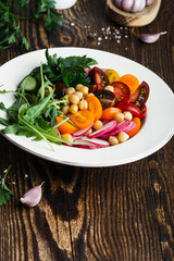 Veggie chickpeas salad with fresh vegetables and herbs, plant based meal