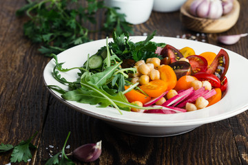 Veggie chickpeas salad with fresh vegetables and herbs, plant based meal