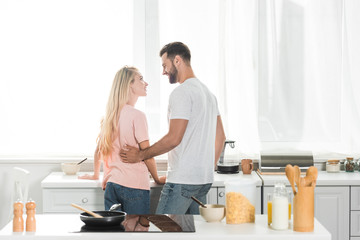 back view of beautiful couple during breakfast at kitchen