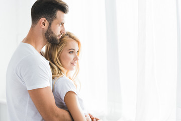 beautiful couple hugging at home in morning with sunlight