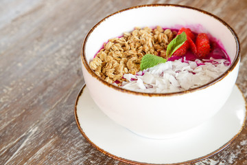 Delicious organic smoothie bowl garnished with dragon fruit, flaxseeds, sliced almonds and granola