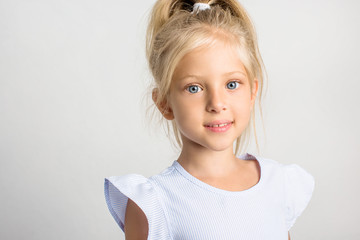 Beautiful girl with blond hair in a blue dress, a 7 year old child