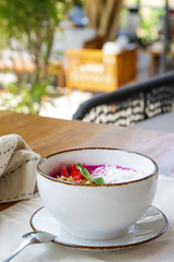 Delicious organic smoothie bowl garnished with dragon fruit, flaxseeds, sliced almonds and granola