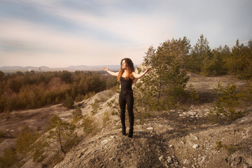 girl on the edge of the mountain with outstretched hands. Freedom, happiness, nature