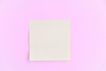 Obraz na płótnie Canvas Empty yellow paper note on pink background. Blank Sticky reminder on neutral backdrop. Mockup concept with paper piece on the board. Memory card with empty space for image or text. Memo sticker 