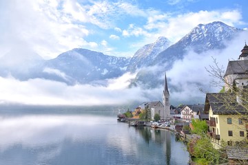 Fototapeta premium Amazing Hallstatt village with beautiful lake and alps mountains on background. Unesco heritage. Austria landmark with historic cathedral and wooden houses on the lake. Romantic view 