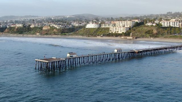 Aerial view of San Clemente Pier with beach and coastline before sunset time . San Clemente city in Orange County, California, USA. Travel destination in the South West Coast. Famous beach for surfer.