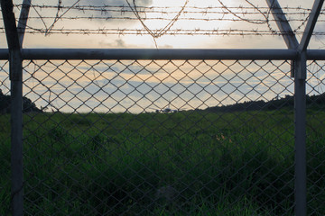 Metal fence wire, War and sky in the background Silhouette in Phuket Thailand