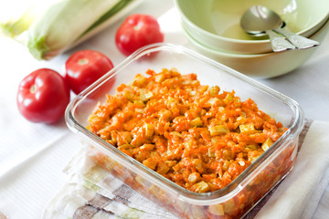 Squash stew with carrot and tomatoes in a square glass dish