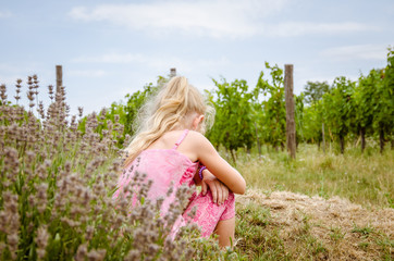 Fototapeta na wymiar little girl back view in green vineyard