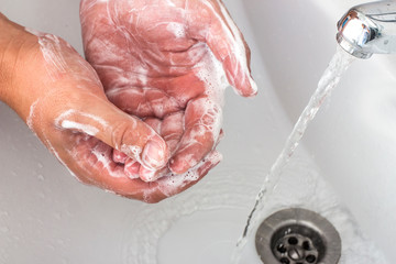 Fototapeta premium The hands of a man who washes his hands with soap dispenser.