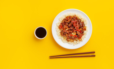 Sweet and sour pork on rice with red peppers, top view, copy space