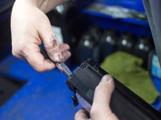 Toner refill printer cartridge. Hand master with pliers repairing a cartridge.