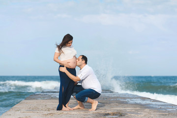 husband kissing belly of pregnant wife