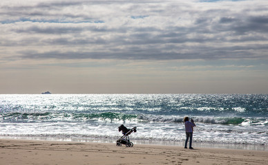 Fototapeta na wymiar Mulher na praia com seu filho