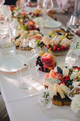 Beautifully decorated catering banquet table with different food snacks and appetizers with sandwich, caviar, fresh fruits on corporate party event or wedding celebration