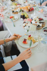 Wedding table setting. Festive table with white tablecloth. guests sit at the table. on the table are fruits, cheeses, glasses. cheese and wine tasting