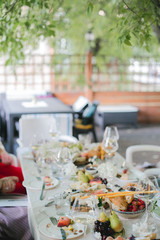 Beautifully decorated catering banquet table with different food snacks and appetizers with sandwich, caviar, fresh fruits on corporate party event or wedding celebration