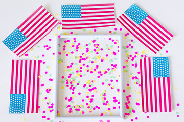 Flat lay composition with the American flag on a white background. Flags of the USA and confetti on a white background. Happy independence day