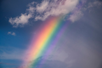 Naklejka na ściany i meble Colorful rainbow in the sky with clouds.