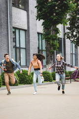 Playful and happy teenagers running with skateboard and smiling