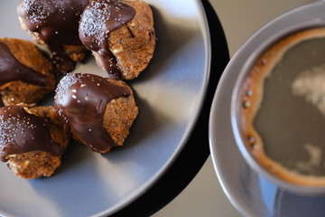 Anthill chocolate cake dessert on a gray plate and cup of coffee . Black table in the kitchen.