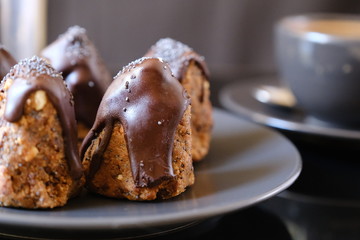 Anthill chocolate cake dessert on a gray plate and cup of coffee . Black table in the kitchen.