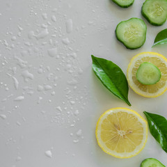 Fototapeta na wymiar Fresh frutti background. Raw lemon and cucumber slices on white background