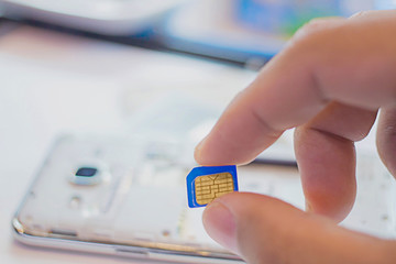 Employees are putting nano SIM cards in the store for customers to buy,Men's hands, changing the SIM card. Time to travel