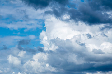 Cumulonimbus  clouds on a summer blue sky. Time before a thunderstorm. Abstract background