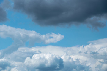 Cumulonimbus  clouds on a summer blue sky. Time before a thunderstorm. Abstract background