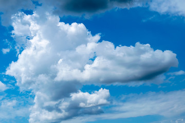 Obraz premium Cumulonimbus clouds on a summer blue sky. Time before a thunderstorm. Abstract background