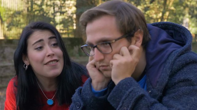 frustrated woman arguing couple Problem with her bored boyfriend in the park