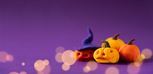 Funny toy pumpkins from plasticine molded children. Scary Halloween background with open space for text. Banner.