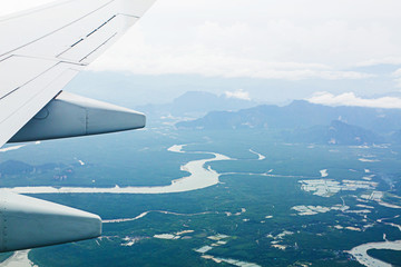 Fototapeta na wymiar High angle view on plane Thailand At daytime,view from the plane window mountains and sea near Phuket Island.