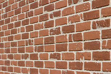 Obraz premium Close up angle view of an exterior brick wall background featuring artificial brick surface simulating worn and weathered brickwork