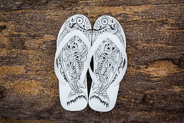 Beautiful white sandals on a wooden stick a tropical beach in Phuket, Thailand.