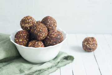 appetizing energy balls in a  white bowl white wooden background