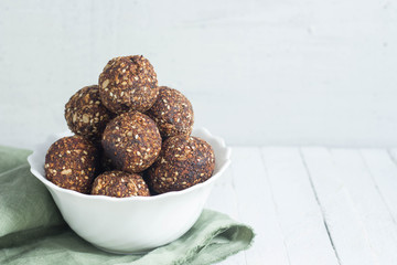 appetizing energy balls in a  white bowl white wooden background