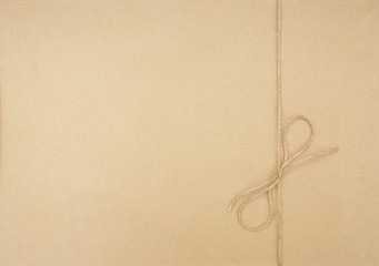 Beige cardboard surface with a rope