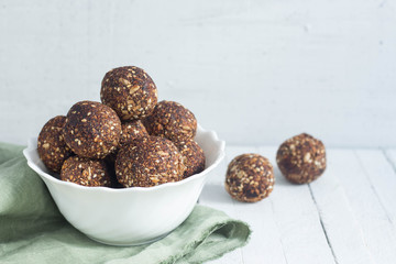 appetizing energy balls in a  white bowl white wooden background
