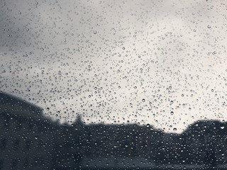 An amazing photography of some waterdrops over the window after summer rain in the city
