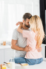 couple hugging on Kitchen Counter during breakfast at kitchen