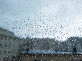 An amazing photography of some waterdrops over the window after summer rain in the city