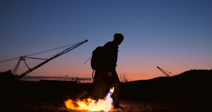 A man with a flamethrower at sunset in slow motion. Costume for zombie Apocalypse and Halloween.