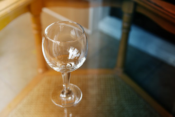 Empty wine glass on a glass table.