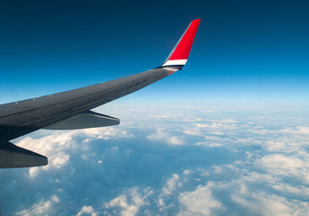 Fototapeta na wymiar Airplane wing high in clouds